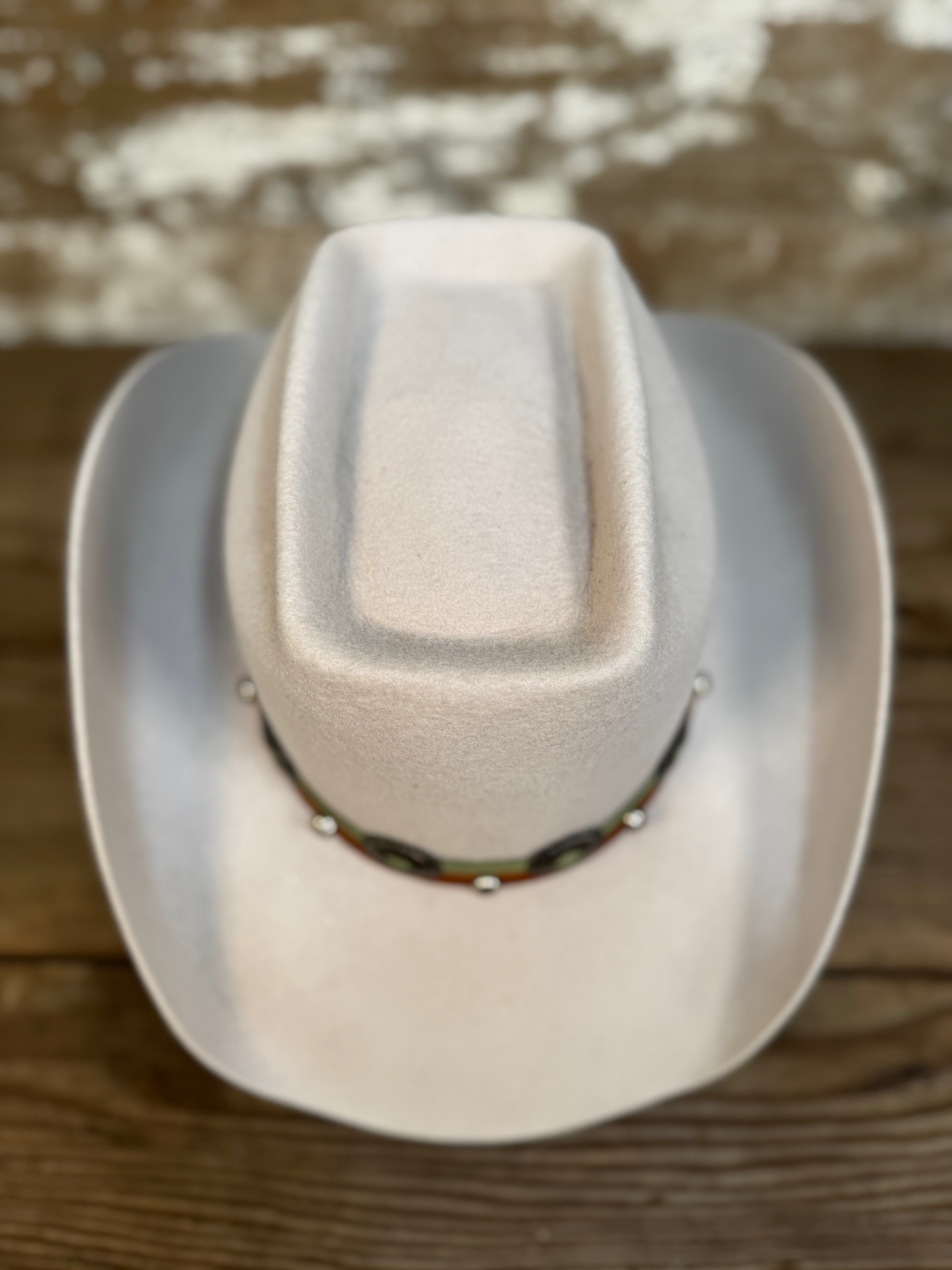 Top view of tan wool cowboy hat with a brick-style crown and come-and-go brim, finished with a smooth leather hat band and silver conchos.