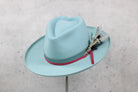 Light blue fedora hat with a pink and blue hatband and decorative feather 