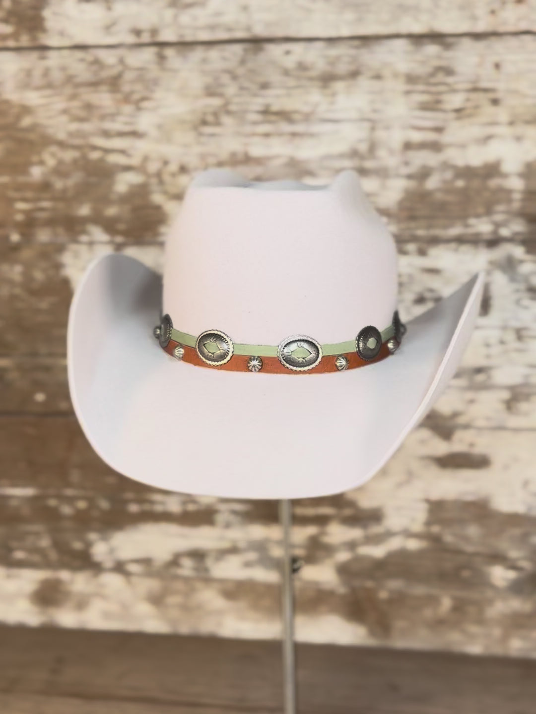 Video of cowboy hat with a brick-style crown and come-and-go brim, finished with a smooth leather hat band and silver conchos.