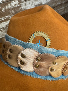 Detail of Solar Communion reclaimed beaver felt hat with denim and fur band, hand-shaped with brass sun detail and wide brim, crafted in Oregon.