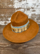 Front view of Solar Communion reclaimed beaver felt hat with denim and fur band, hand-shaped with brass sun detail and wide brim, crafted in Oregon.