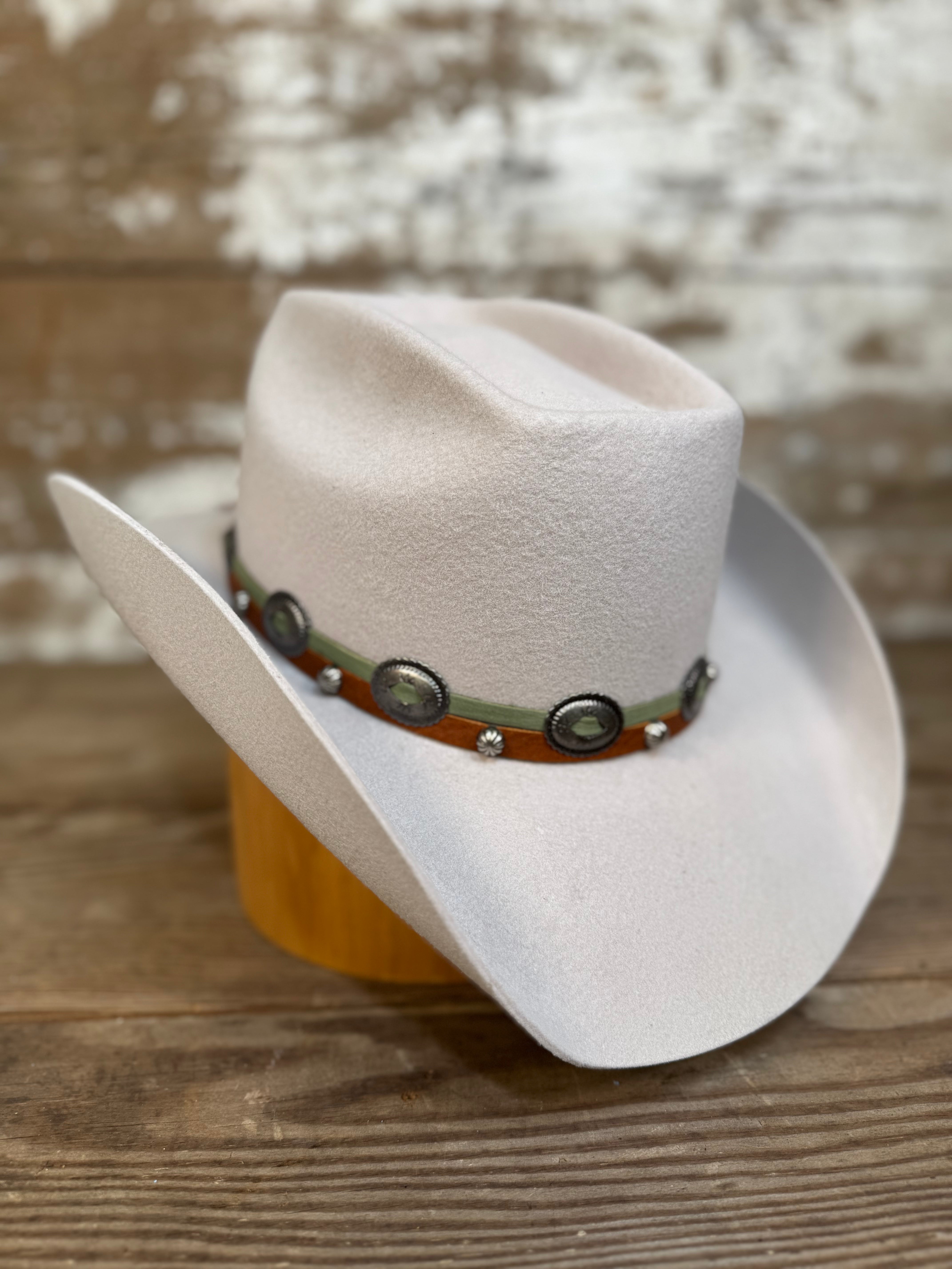 Tan wool cowboy hat with a brick-style crown and come-and-go brim, finished with a smooth leather hat band and silver conchos.