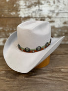 Tan wool cowboy hat with a brick-style crown and come-and-go brim, finished with a smooth leather hat band and silver conchos.